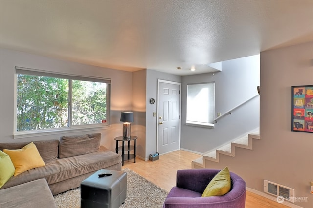 living room with a textured ceiling and light wood-type flooring