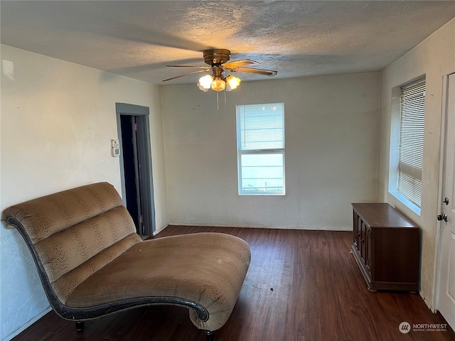 sitting room featuring a textured ceiling, dark hardwood / wood-style flooring, and ceiling fan