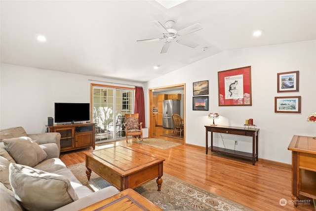 living room with ceiling fan, hardwood / wood-style flooring, and lofted ceiling with skylight