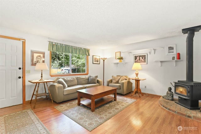 living room featuring hardwood / wood-style floors, a textured ceiling, and a wood stove