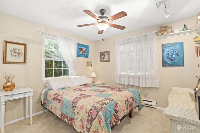 bedroom with light carpet, baseboard heating, a textured ceiling, and ceiling fan