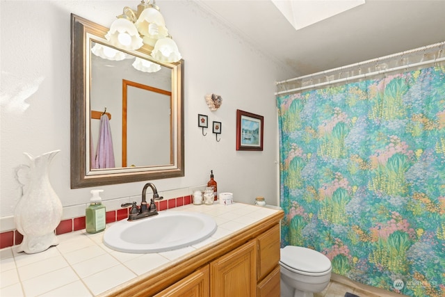 bathroom with a skylight, vanity, tile patterned floors, a shower with curtain, and toilet