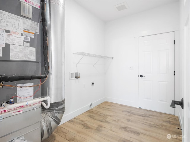 334 Spring Cir SW Unit 69, Mattawa, WA 99349 - clothes washing area with wood finished floors, laundry area, heating unit, electric dryer hookup, and hookup for a washing machine