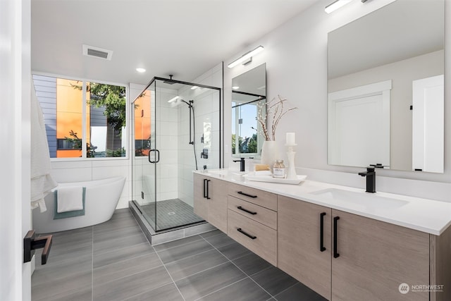 bathroom featuring independent shower and bath, vanity, and tile patterned floors