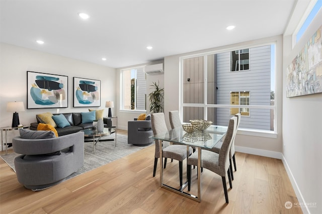 dining space featuring light hardwood / wood-style floors and an AC wall unit