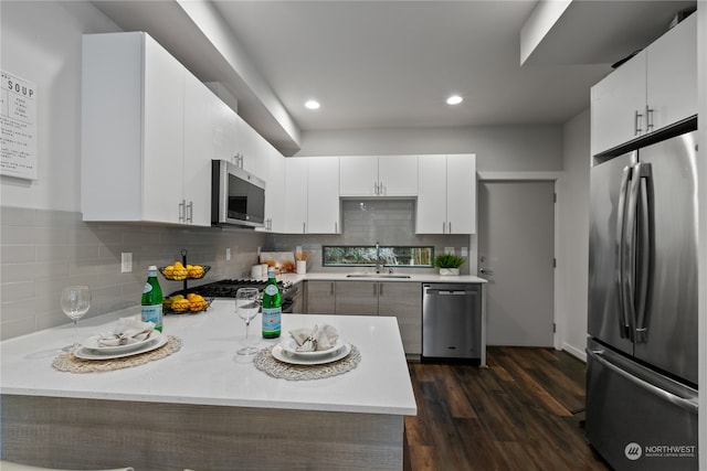 kitchen featuring dark wood-type flooring, appliances with stainless steel finishes, and white cabinets