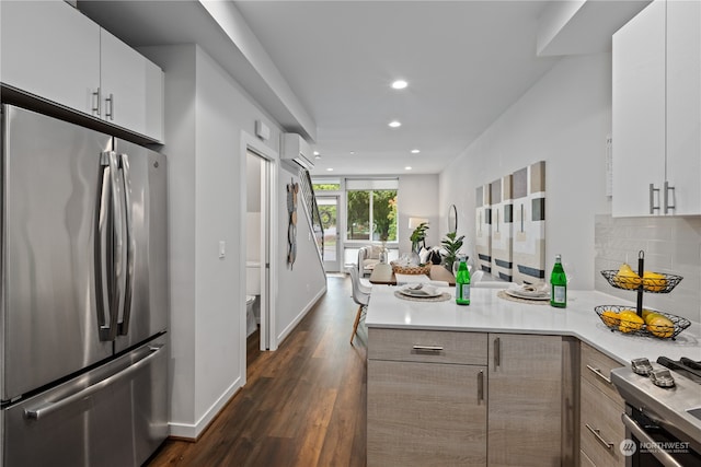 kitchen with white cabinets, a wall mounted AC, tasteful backsplash, dark hardwood / wood-style flooring, and appliances with stainless steel finishes