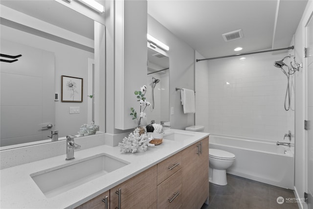 full bathroom with tiled shower / bath, vanity, toilet, and tile patterned floors