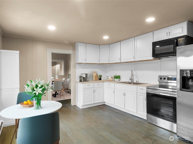 kitchen with stainless steel appliances, dark hardwood / wood-style flooring, and white cabinetry