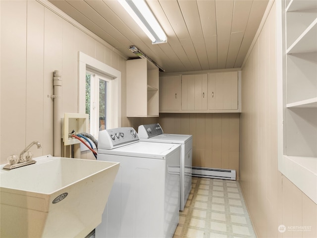 clothes washing area with independent washer and dryer, sink, crown molding, wood walls, and baseboard heating