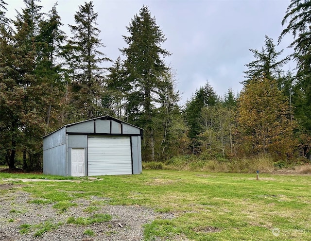 view of outdoor structure featuring a garage and a yard