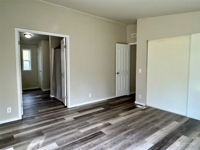 unfurnished room with ornamental molding and dark wood-type flooring