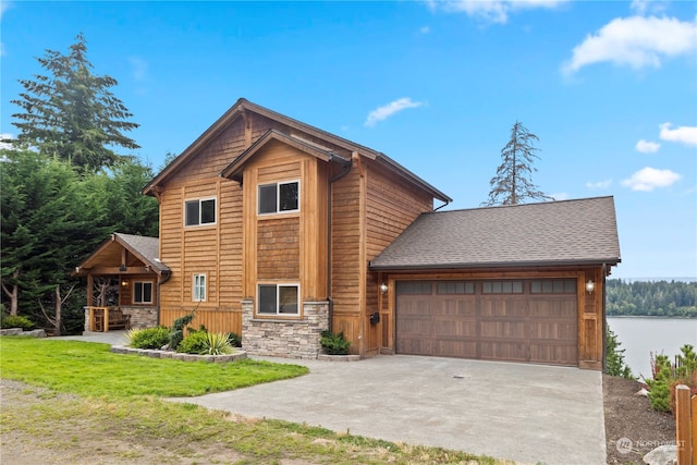 view of front facade with a garage, a water view, and a front yard