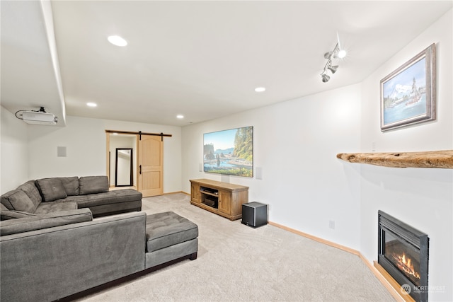 living room with light colored carpet, rail lighting, and a barn door