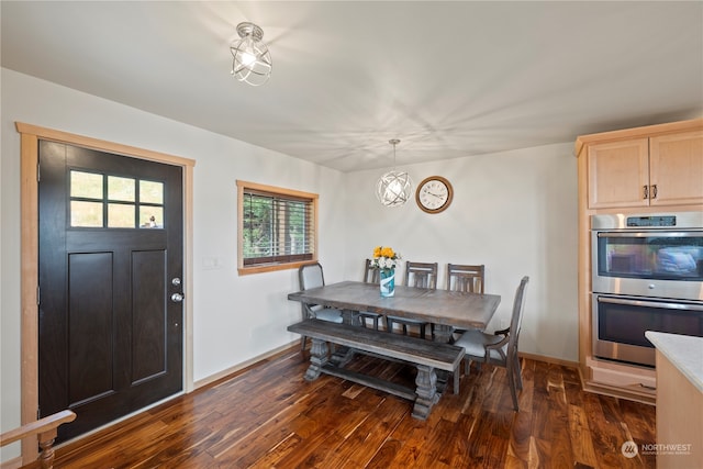 dining space with an inviting chandelier and dark hardwood / wood-style flooring