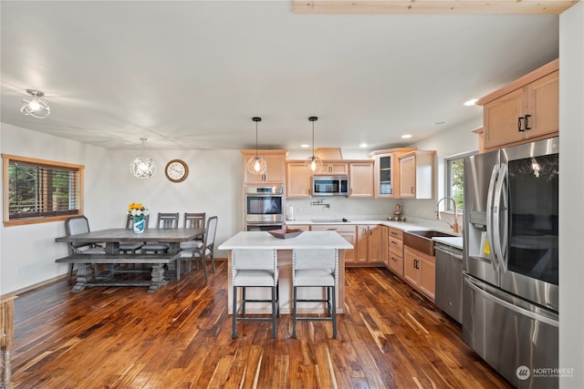 kitchen with light brown cabinetry, sink, appliances with stainless steel finishes, a kitchen island, and pendant lighting