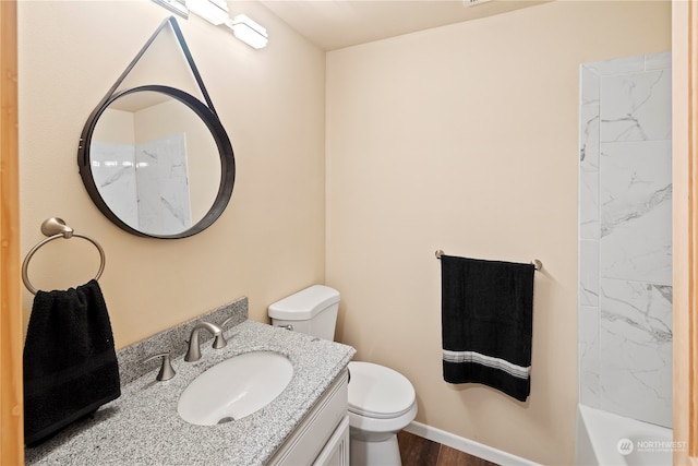 full bathroom featuring vanity, hardwood / wood-style floors, toilet, and washtub / shower combination