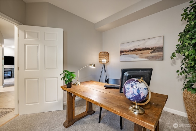 home office with a fireplace and carpet