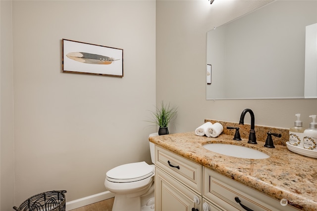 bathroom featuring vanity, tile patterned flooring, and toilet