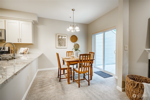 carpeted dining space with an inviting chandelier and sink