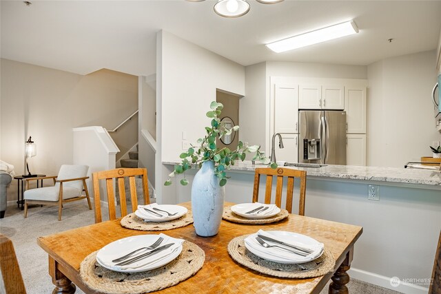 dining room with light colored carpet and sink