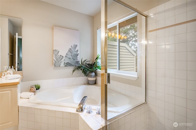 bathroom with tiled bath and vanity