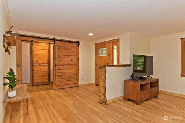 living room featuring a barn door, light hardwood / wood-style flooring, and ornamental molding