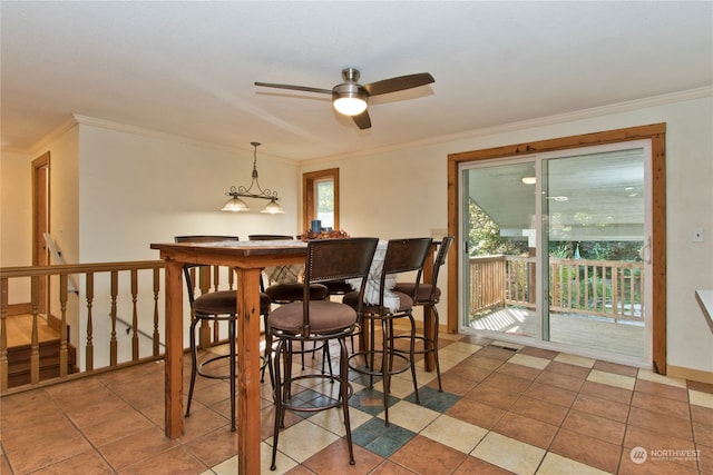 tiled dining space with ceiling fan and ornamental molding