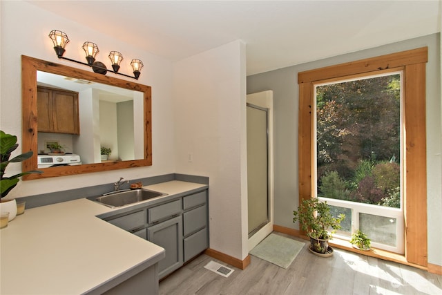 bathroom featuring wood-type flooring, vanity, and a shower with shower door