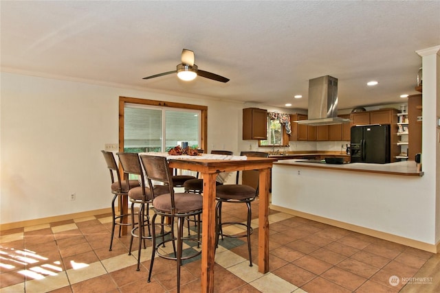 tiled dining room featuring ceiling fan, crown molding, and sink