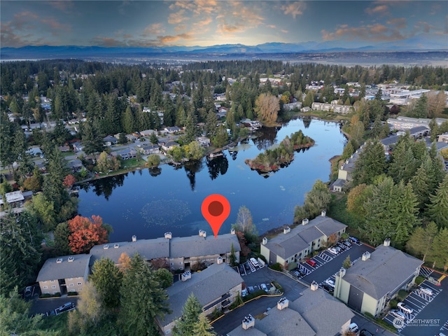 aerial view at dusk featuring a water view