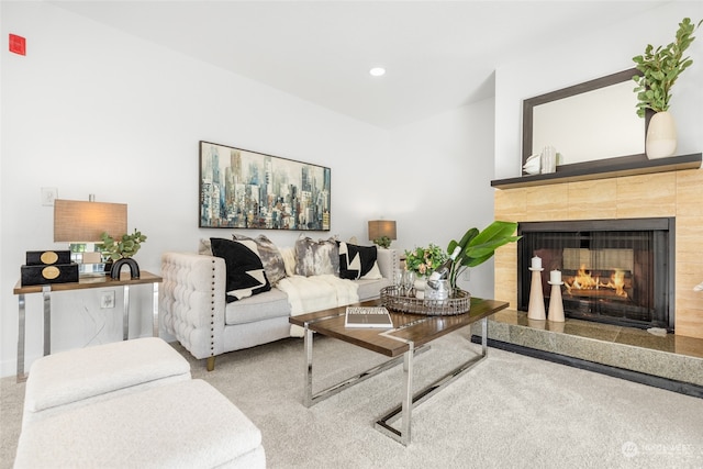 carpeted living room with a tiled fireplace