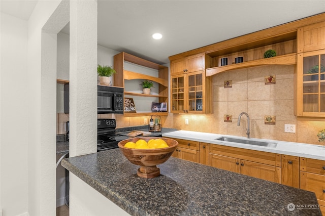 kitchen with dark stone counters, sink, and decorative backsplash