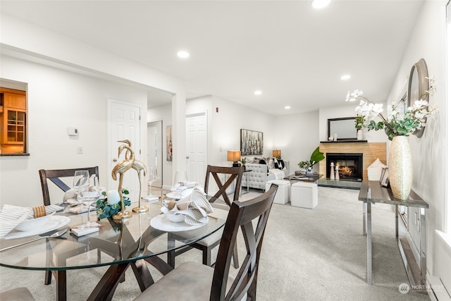 dining space with baseboard heating and light carpet