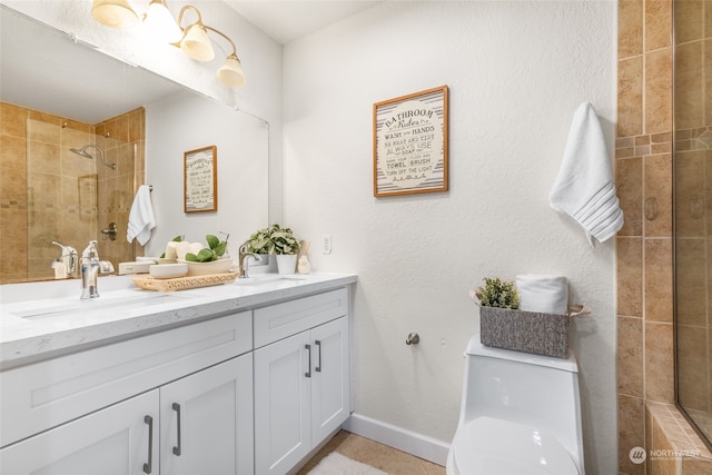 bathroom with vanity, toilet, and tiled shower