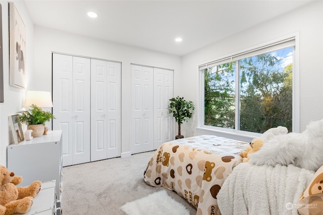 carpeted bedroom featuring two closets