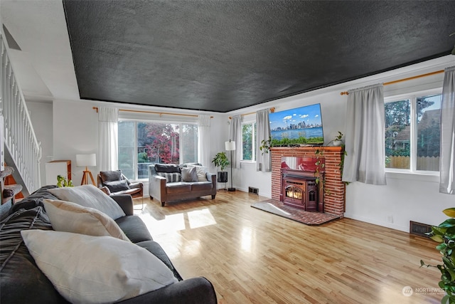 living room featuring plenty of natural light, light hardwood / wood-style floors, and a textured ceiling