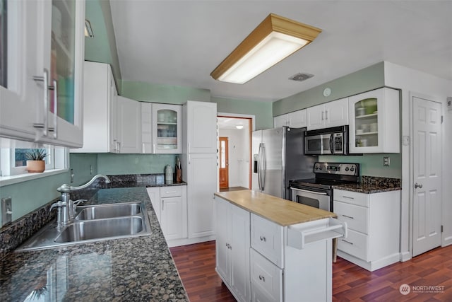 kitchen with white cabinetry, stainless steel appliances, and dark hardwood / wood-style flooring