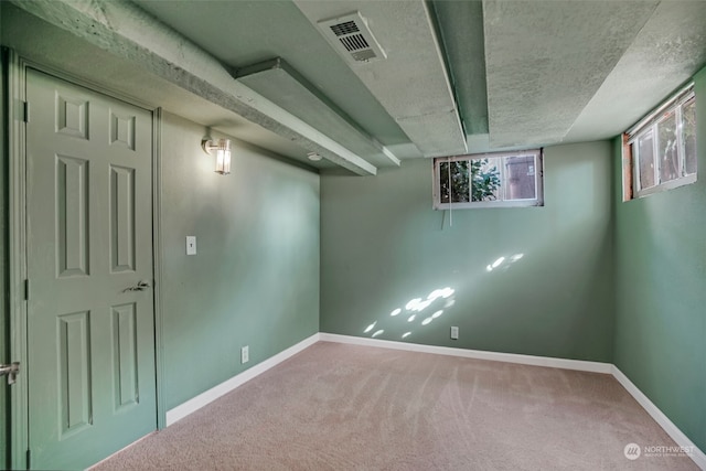 basement with carpet and a textured ceiling