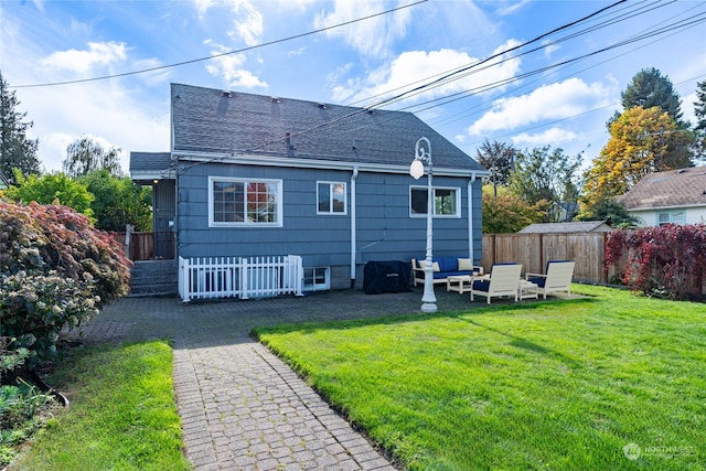 back of property with a yard and a patio