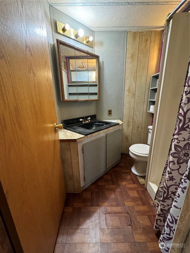 bathroom with a textured ceiling, a shower with shower curtain, vanity, and toilet