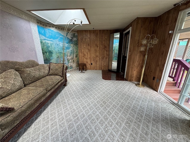 living room with a skylight, wood walls, and carpet