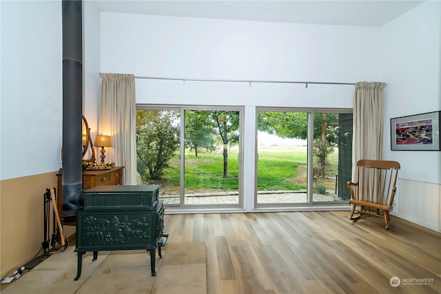 sitting room featuring a wood stove, a wealth of natural light, and light hardwood / wood-style flooring