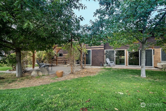 rear view of house featuring a patio area and a lawn