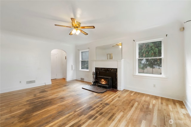 unfurnished living room with ceiling fan, plenty of natural light, and light wood-type flooring