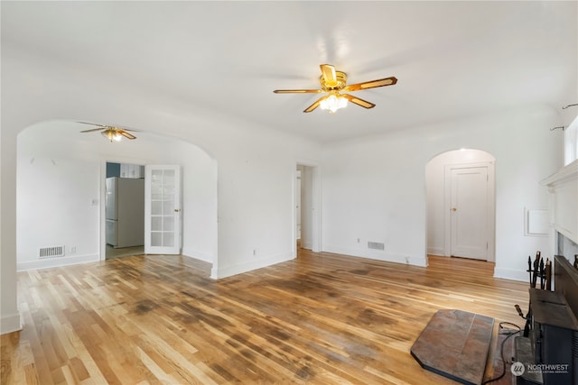 unfurnished living room featuring ceiling fan and light hardwood / wood-style flooring