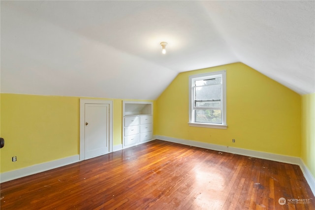 bonus room with wood-type flooring and vaulted ceiling