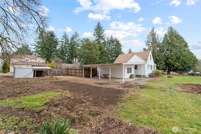 rear view of house with an outbuilding and a yard