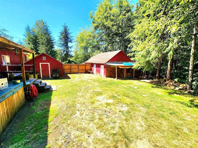 view of yard featuring a storage shed, a fenced backyard, a detached garage, and an outdoor structure