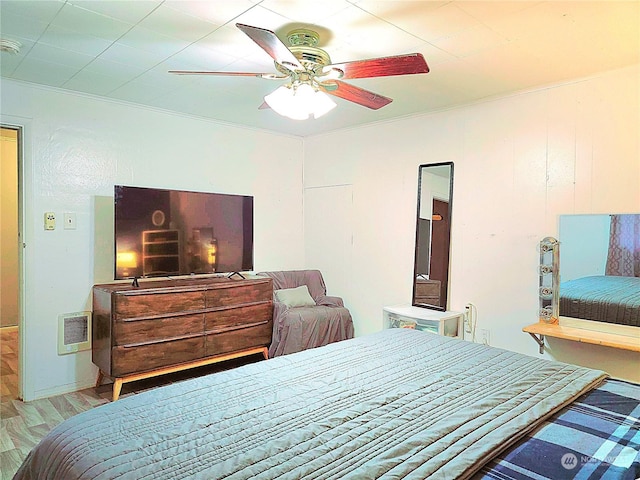 bedroom featuring crown molding, ceiling fan, and light wood-style flooring